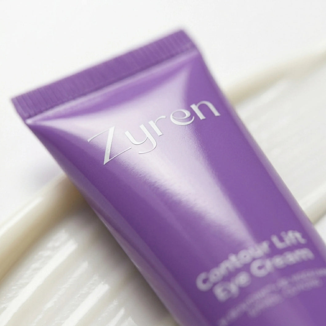 Close-up of the purple Zyren Contour Lift Eye Cream tube resting on a swatch of white cream