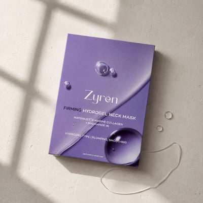 Zyren Firming Hydrogel Neck Mask box lying on a sunlit surface next to drops of clear gel